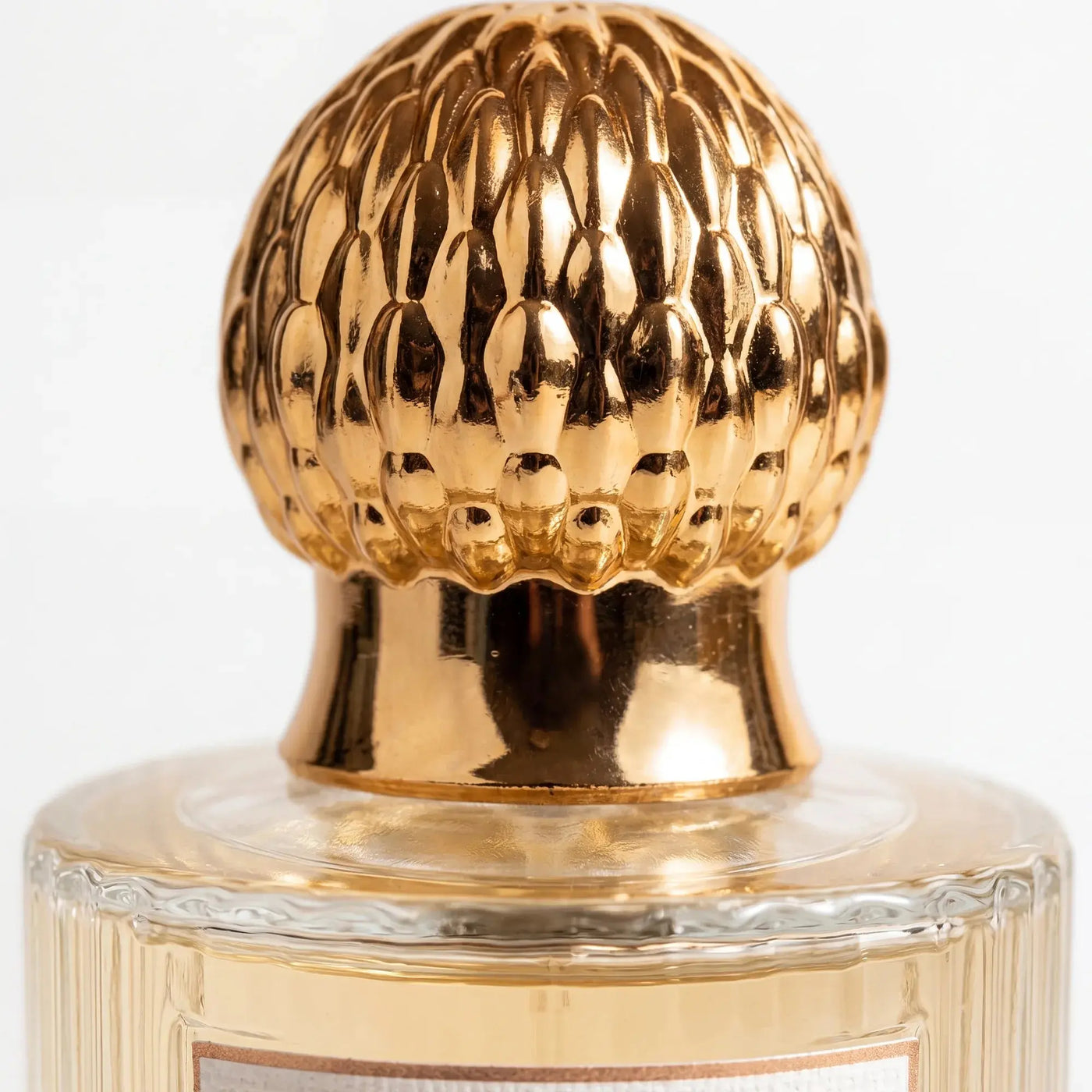 Close detail of the Qanzari Lamees gold filigree dome cap against warm shadow
