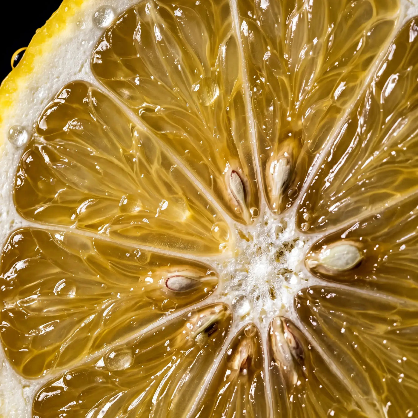 Cut lemon on cream linen beside the Qanzari Lamees bottle, the perfume's cold citrus top note